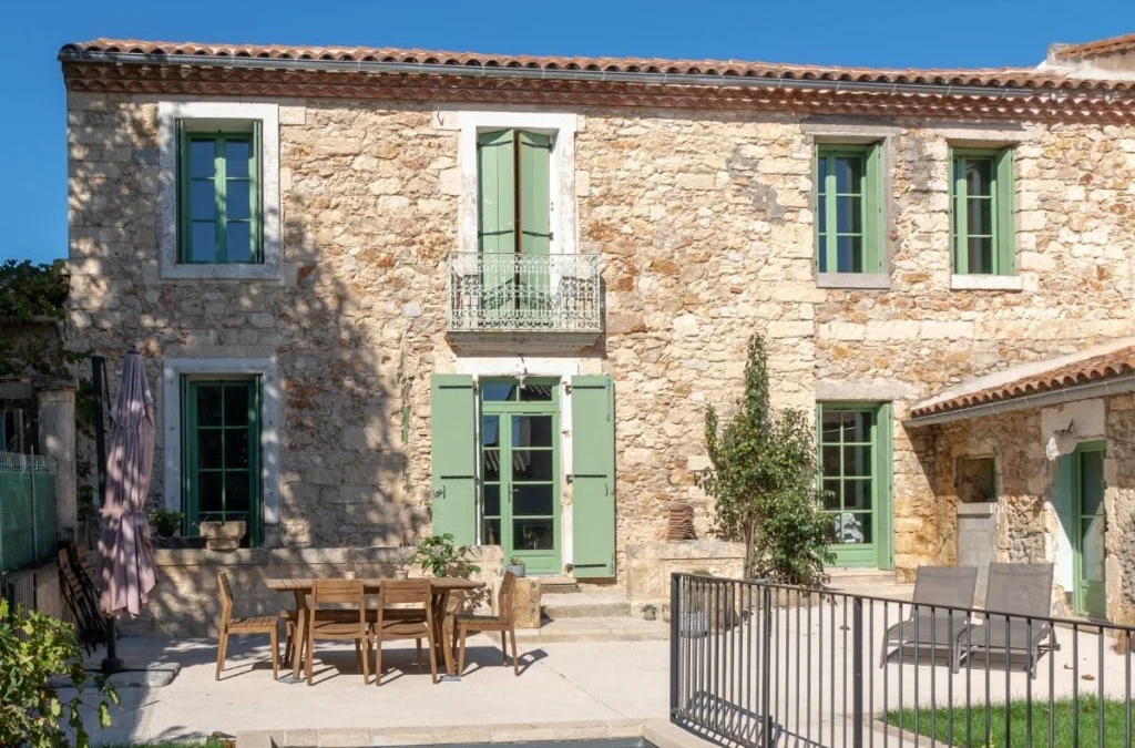 Maison en pierre à Castries avec des volets verts