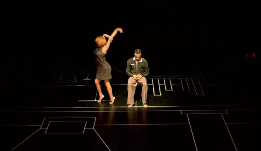 Deux artistes en plein spectacle sur une scène sombre